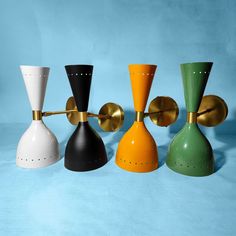 four different colored vases are lined up on a blue background and one is gold