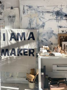 an artist's studio with various pieces of art on the wall