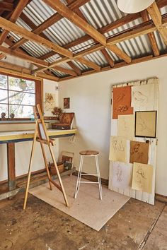 an artist's studio with various pieces of art on the wall and in the floor