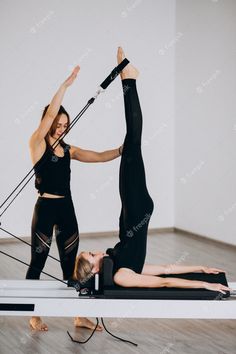 two women doing pivots on exercise mats in a room with white walls and wood flooring