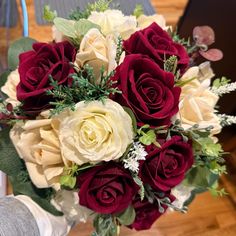 a bouquet of red and white roses on a table