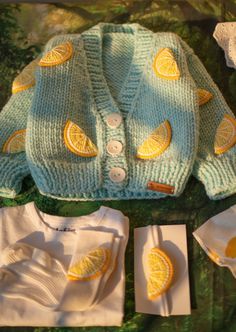 a knitted sweater with lemons on it and two ones sitting next to each other