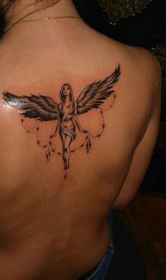 a woman's back with a tattoo on her left shoulder and an angel above it