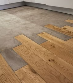 an empty kitchen with wood floors and white cabinets