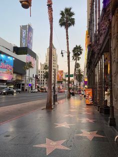 the hollywood walk of fame star is shown in front of palm trees and tall buildings