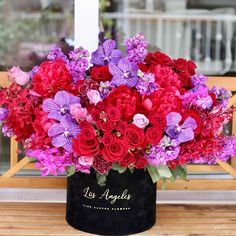 a bouquet of red and purple flowers on a bench