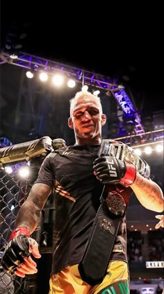 a man with white hair and tattoos standing in front of a cage holding a pair of gloves