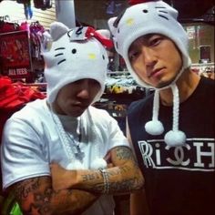 two young men wearing hello kitty hats in a clothing store, one is looking at the camera