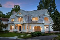 a large white house with lots of windows on it's roof and two car garages