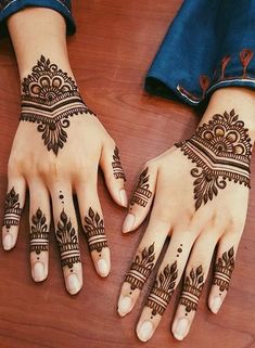 two hands with henna tattoos on them