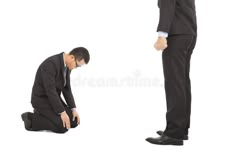 a man kneeling down while looking at another man in suit and tie