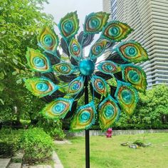 a metal sculpture in the shape of a peacock's tail on top of a pole