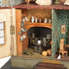 an old fashioned doll house with furniture and accessories on the shelves in front of it