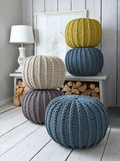 three knitted balls sitting on top of each other in front of a fireplace mantel