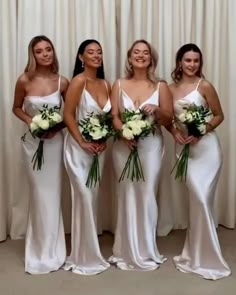 the bridesmaids are all dressed in white gowns and holding their bouquets