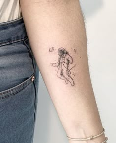 a woman's arm with a tattoo on it that has an astronaut in space