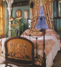 a bedroom with a bed, mirror and window in the corner is decorated in antique style