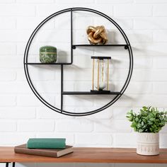 a round metal shelf with books on it next to a potted plant and book