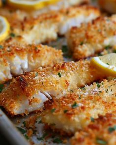 fish fillets with lemon wedges and parmesan cheese