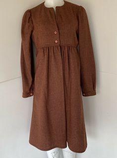 Vintage 1970s Gil Aimbez Genre Wool Dress Brown sz M  EXCELLENT CONDITION! - but the size tag/material content tag were cut out feels like wool - the chest area is lined Please see measurements provided for an accurate fit HERE ARE THE MEASUREMENTS:  LENGTH: (from the top of the shoulder to bottom hem) 42"  WAIST: (HIGH WAIST WHERE THE PIPING IS) 16" ACROSS   UNDERARM TO UNDERARM: 18"  SLEEVE LENGTH: 24"  ALL MEASUREMENTS TAKEN WHILE LAYING FLAT. Retro A-line Vintage Dress For Fall, Vintage Winter Daywear Dresses, Retro Vintage Dress For Fall, 1970s Vintage Dress For Fall, 1970s Style Vintage Fall Dress, 1970s Fall Vintage Dress, Brown Vintage Dress For Fall, Fall Vintage Brown Dress, Retro Vintage Dress For Fall Daywear