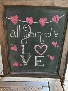 a chalkboard with hearts and the words all you need is love