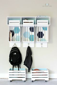 two white cubbys are next to a wall with bookshelves and coat racks