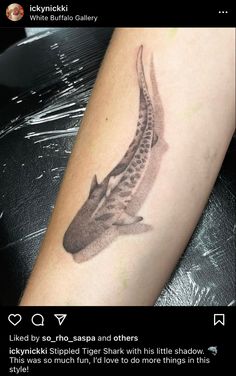 a tattoo on the arm of a person with a fish in it's mouth