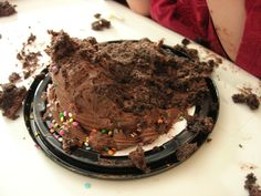 a cake with chocolate frosting and sprinkles sitting on top of a plate