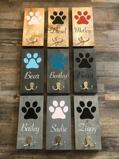 six dog door hangers with paw prints and names on them, all in different colors