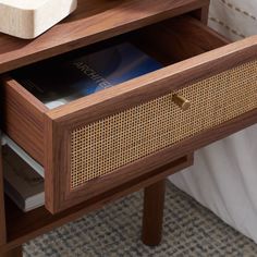 a close up of a drawer on a bed with a book and other items in it