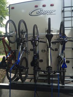 a trailer with bikes attached to the back of it's sides and two bicycles on top