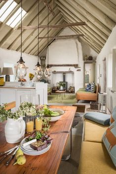 a dining room table with food and drinks on it in front of a kitchen area