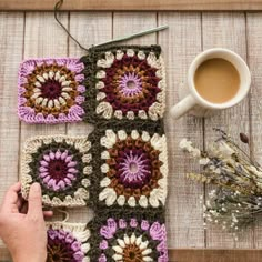 someone is crocheting squares on the table next to a cup of coffee and flowers