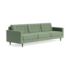 a green couch sitting on top of a white floor