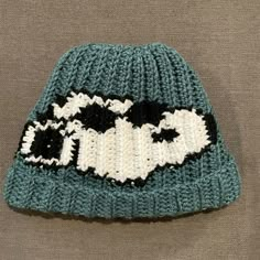 a knitted hat with black and white sheep on it