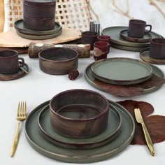 a table set with plates, cups and utensils