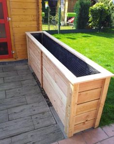 a wooden planter box sitting on top of a brick walkway