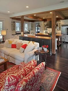 a living room filled with furniture and a kitchen in the backgroung area