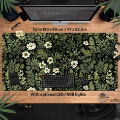 a computer keyboard sitting on top of a desk next to a plant covered wallpaper