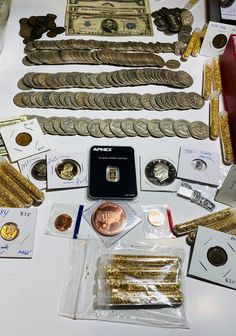 a table topped with lots of different types of gold coins and other assorted items