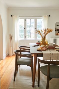 a dining room table and chairs in front of a window