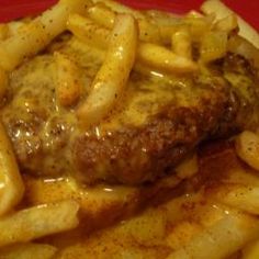 a plate with french fries and meat covered in gravy