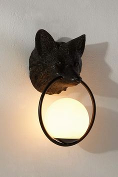 a cat head mounted on the side of a wall light