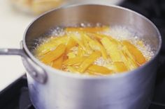 a pot filled with food sitting on top of a stove next to a burner