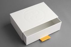 an empty white box with a yellow piece of paper sticking out of the top and bottom