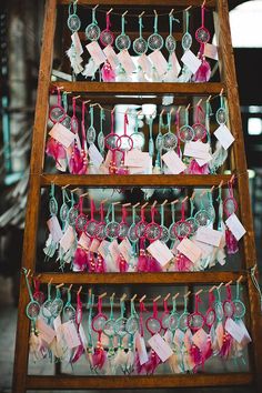 a wooden ladder filled with lots of wine glasses on top of hangers and tags