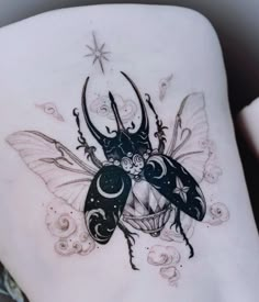 a woman's back with a tattoo design on her stomach and an image of a bug