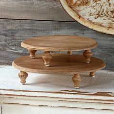 three tiered wooden cake stand sitting on top of a table