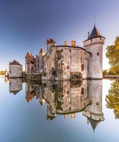 an old castle is reflected in the water