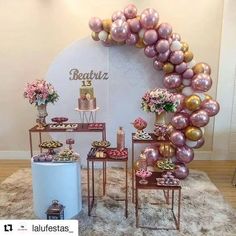 the dessert table is set up with pink and gold balloons on it, along with other decorations